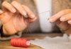 man putting a thread through a needle