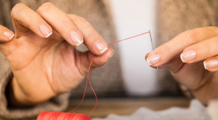 How to Pick the Best Yarn Needle – The Ultimate Guide man putting a thread through a needle